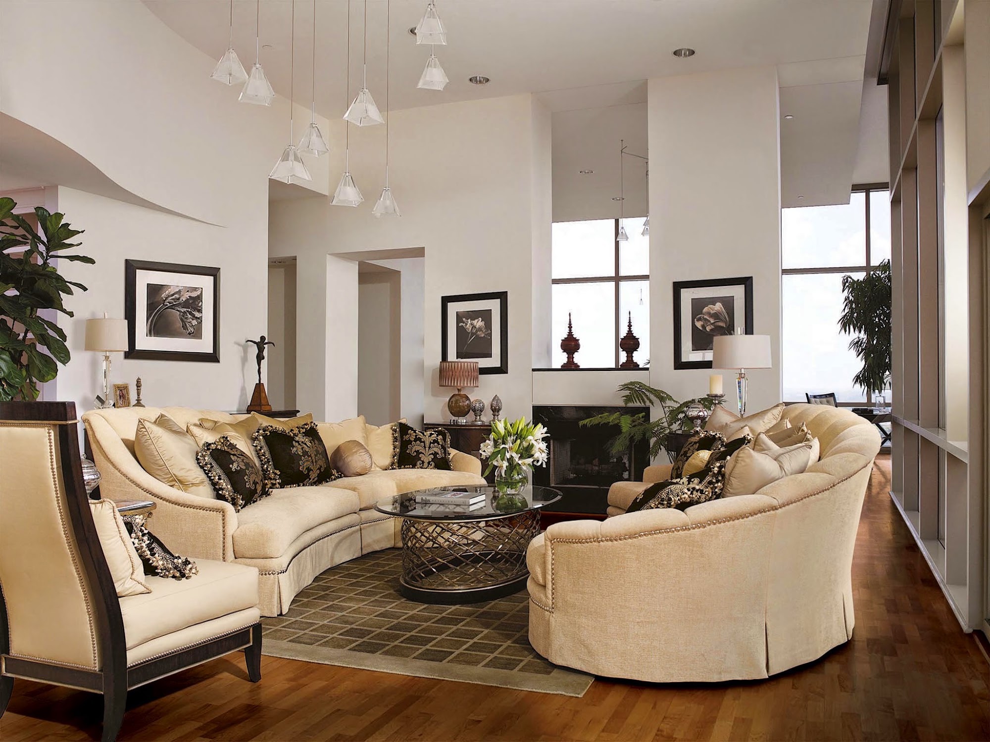 Sunken great room with curved sectional sofas around a glass coffee table