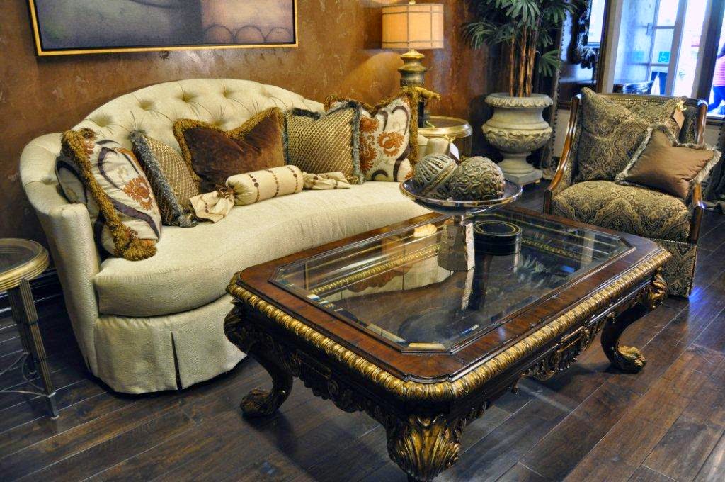 Traditional tufted sofa and carved wood coffee table in a warm sitting room