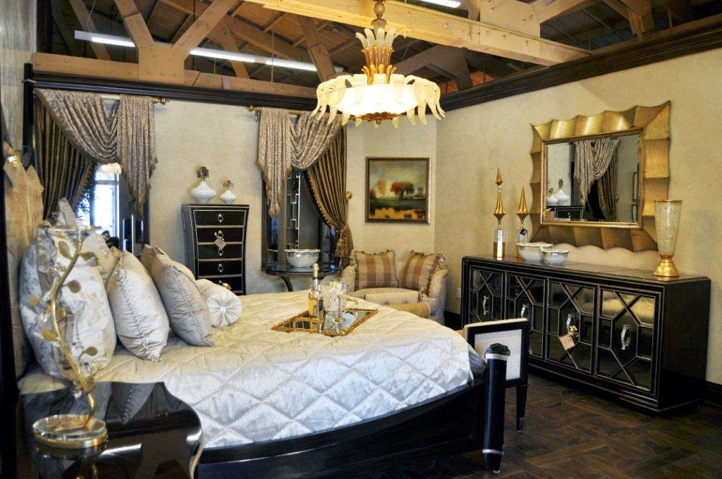 Draped primary bedroom with layered curtains and warm ambient lighting